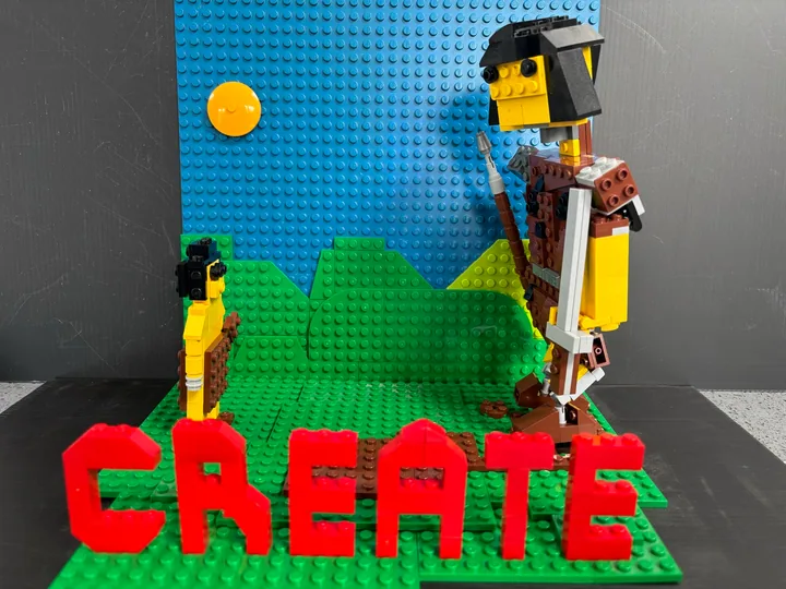 Red CREATE lettering beneath a small figure and a much taller brick-built figure.