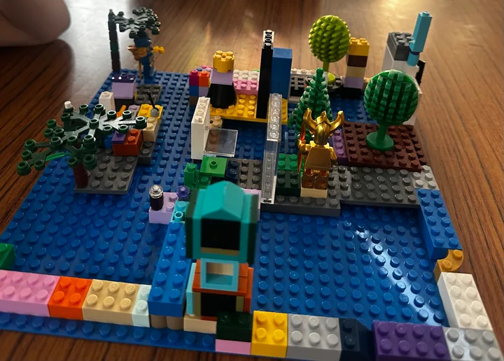 A miniature town with trees, colourful buildings and a vehicle.